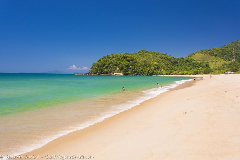 Imagem de mae pai e filho no mar calmo da Praia de Prumirim.